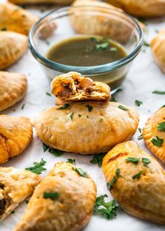 several pastries on a table with dipping sauce