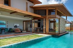 a house with a pool in front of it and an open patio area next to it