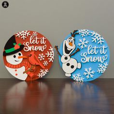 two snowman plates sitting on top of a wooden table