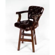 a brown leather chair sitting on top of a white floor next to a wooden bar stool