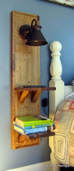 a wooden shelf with books on it next to a bed