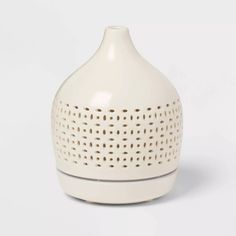 a white vase sitting on top of a table