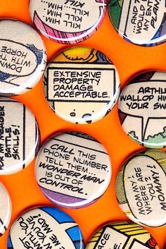 several buttons that have been placed on an orange surface with words written in different languages