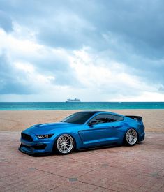 a blue sports car parked on the beach