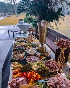 a table topped with lots of food next to a vase filled with flowers and greenery