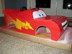 a cardboard race car with lightning bolt on it's side sitting in front of a door