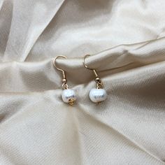 This is an elegant, minimalist , Pearl earring. These earrings are a great gift for anyone or a piece to level up your collection! -DETAILS- - Ivory Freshwater Pearl  - Gold colour hardware - Water resistant  -CARE-  - To avoid extreme tarnishing reduce contact with lotions, oils, and fragrances  - No abrasive materials should come in contact with the piece  - To clean simply fill a bowl with some soapy water do a cloth into the water and wipe  - If you need any repairs feel free to message us -SHIPPING- - We ship all of our orders with regular letter mail  - All of our orders are packaged with love and care -QUESTIONS- - If you have any questions or concerns feel free to message us  - If you want an order specially packaged you can message with requirements  - You can always personalize y Minimalist Single Pearl Drop Earring, Minimalist Drop Pearl Earrings, Minimalist Dangle Earrings With Pearl Charm, Minimalist White Hoop Earrings With Pearl Drop, Everyday Drop Earrings With Pearl Charm, Handmade Pearl White Minimalist Earrings, Handmade Minimalist Pearl White Earrings, Pearl White Pierced Earrings For Gift, Adjustable Pearl White Dangle Earrings