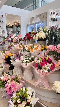 a bunch of flowers that are sitting on some steps in a store or flower shop