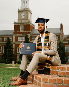 a man sitting on the steps in front of a building with a graduation cap and gown