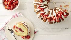 a bundt cake with sliced strawberries on it and a fork next to it