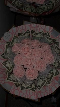 two plates with pink roses on them and money in the middle one is $ 1