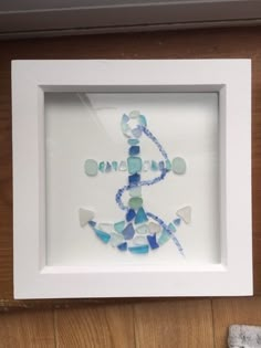 a white frame with some blue and white glass beads in it