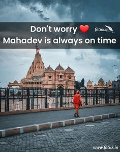 a man walking down the street in front of a building with a sign that says don't worry mahadev is always on time