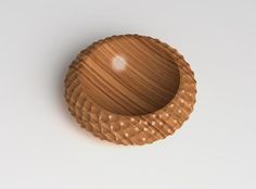 a wooden bowl sitting on top of a white table next to a brown object in the middle