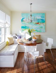 a dining room table with white chairs next to a bench and window in front of it