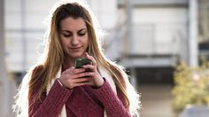 a woman is looking at her cell phone