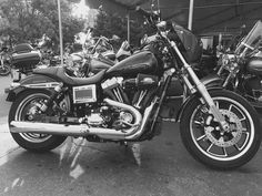 black and white photograph of motorcycles parked under a tent