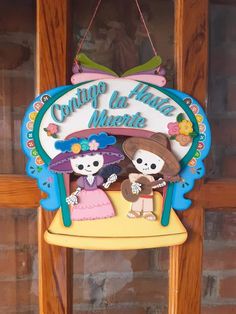 a sign hanging from the side of a wooden door with two cartoon characters on it