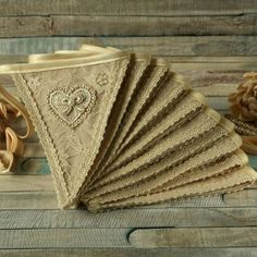 several pieces of lace sitting on top of a wooden table next to some pine cones