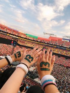 two hands with numbers painted on their palms at a sporting event in an outdoor arena