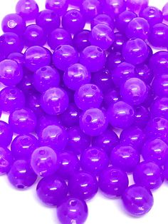 some purple beads are on a white surface