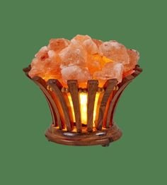 himalayan salt lamp with wooden stand on green background