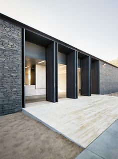 the entrance to an empty building with black doors