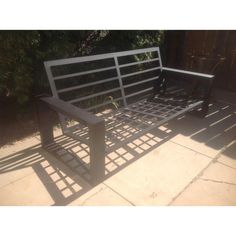 a metal bench sitting on top of a sidewalk