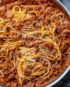 spaghetti with meat sauce and parmesan cheese in a pan