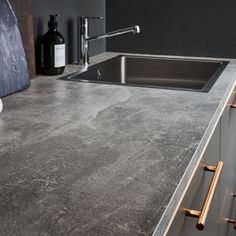 a kitchen counter top with a sink and soap dispenser next to it