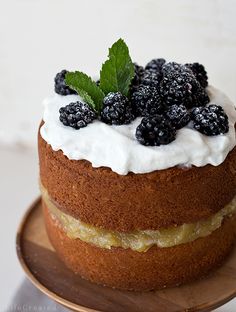 a cake with white frosting and blackberries on top