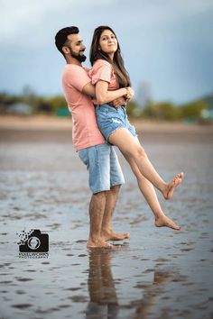 a man and woman standing in the water with their arms around each other as they hug