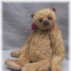 a brown teddy bear sitting on top of a white floor next to a gray wall