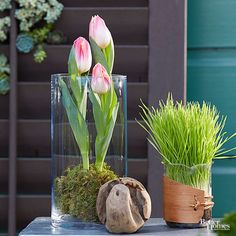 three vases with flowers and grass in them