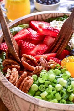 a wooden bowl filled with fruit and nuts