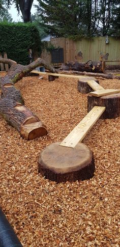 a wooden bench sitting on top of a pile of wood next to a tree stump