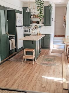 a kitchen with wooden floors and green cabinets