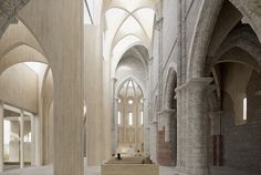 the interior of an old cathedral with stone columns and arches on either side, looking towards the altar