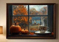 a cup and saucer sit on a window sill in front of an autumn scene