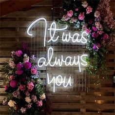 there is a neon sign that says it was always you with flowers on the wall