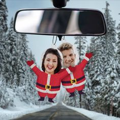 two people dressed as santa clause hanging from the rearview mirror