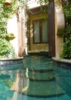 an outdoor swimming pool with steps leading to the door