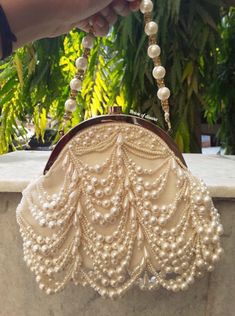 This is a beautiful handcrafted potli bag made with love.It has intricate handwork which showcases the Indian craftsmanship by our local artisans. It comes with a matching pearl handle. Details  - Both side handwork  - Fabric lining on the inside to keep your belongings safe  - Magnetic lock closure  - Detachable handle This clutch can be worn as a crossbody bag or a shoulder bag with the sling chain or can simply be carried in hand.It is spacious enough to carry mobile phones, lipsticks, Keys a Wedding Gifts Indian, Ivory Clutch, Indian Accessories, Potli Bag, White Clutch, Magnetic Lock, Potli Bags, Party Clutch, Luxury Bag