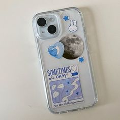 an iphone case with some stickers on it and the moon in the back ground