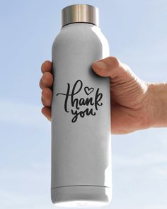 a hand holding a stainless steel water bottle with the words thank you written on it