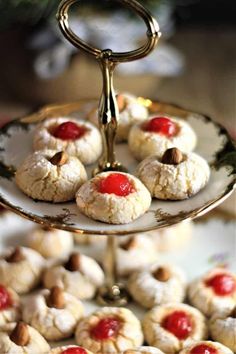 small pastries are displayed on a plate with a gold stand and pine tree in the background