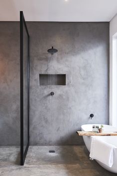 a modern bathroom with concrete walls and flooring