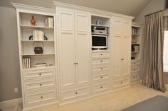 a bedroom with built in cabinets and bookshelves