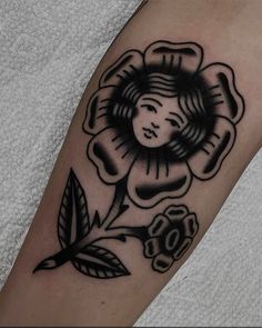 a woman's arm with a flower and leaves tattoo design on the left forearm