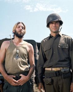 two men standing next to each other wearing helmets